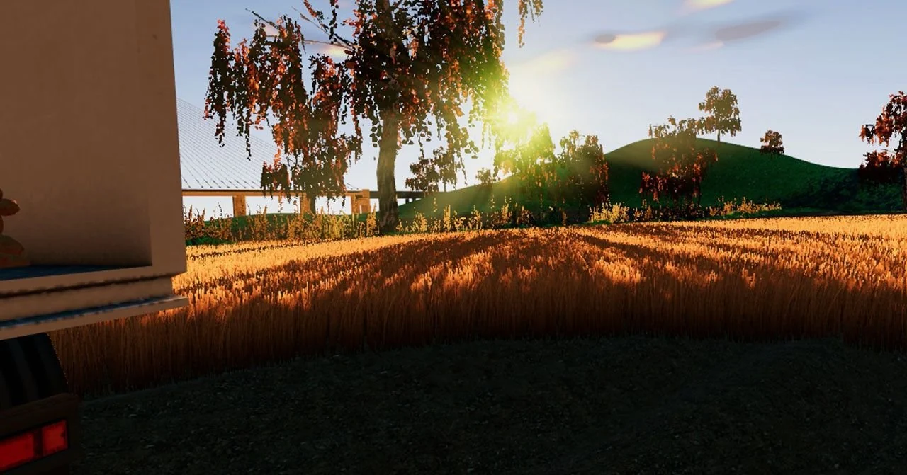 Champ de blé au soleil couchant dans la simulation Vico, un bâtiment d'exploitation au premier plan.