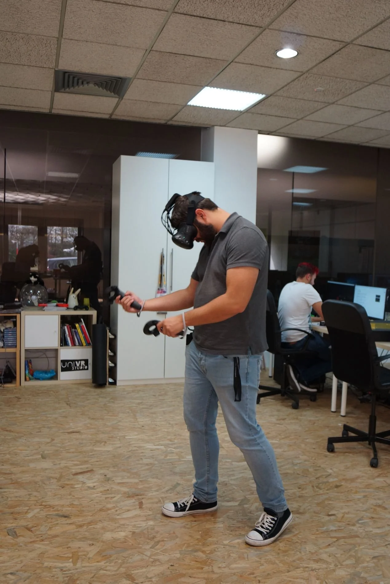 Un utilisateur évolue sans fil au milieu des bureaux, casque et manettes en main.